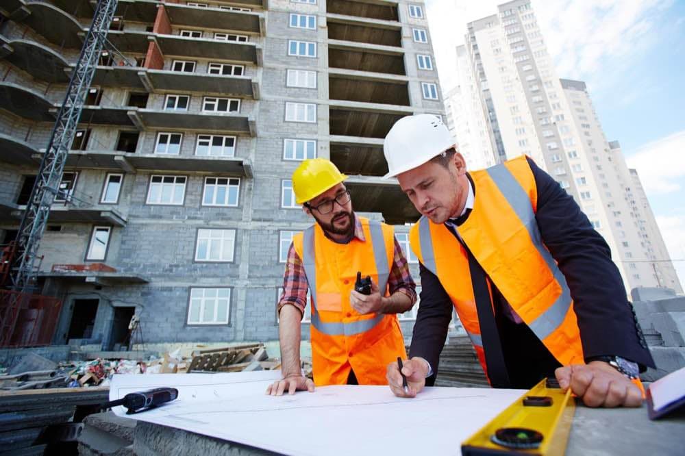 An owner and an adviser working through plans together on site